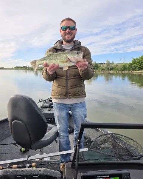 Brad Penske with a largemouth bass on the boat