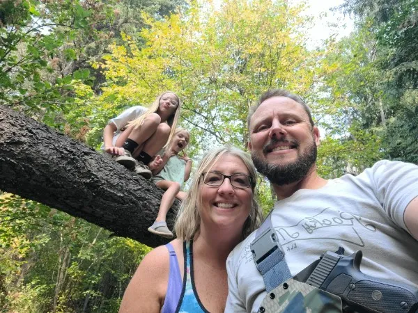 The Penske family outdoors in the trees